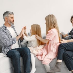 A joyful family spends quality time together, playing and bonding on a cozy sofa.